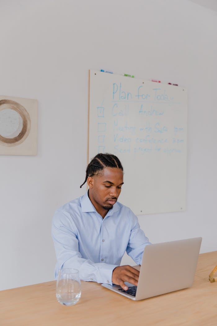 brand-02 Professional man working on a laptop in an office setting, showing concentration and focus.