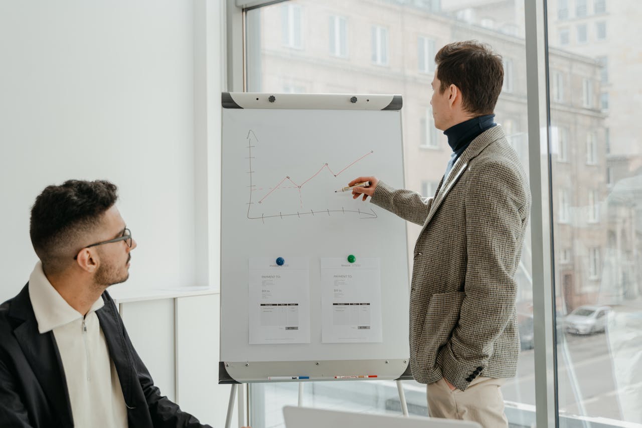 brand-03 Two professionals examining graphs during an office presentation.