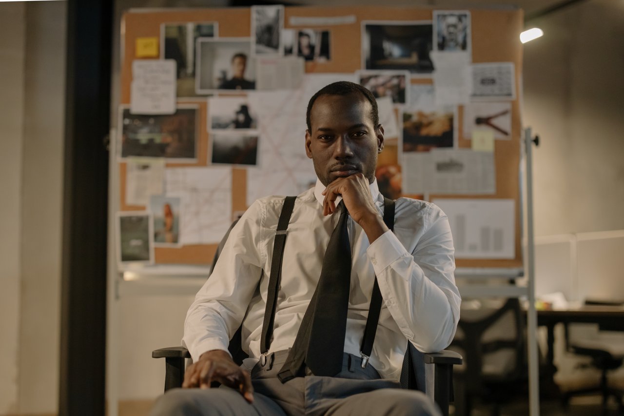 creative-03 Focused detective in a modern office setting, analyzing a crime board. Cinematic and intense mood.