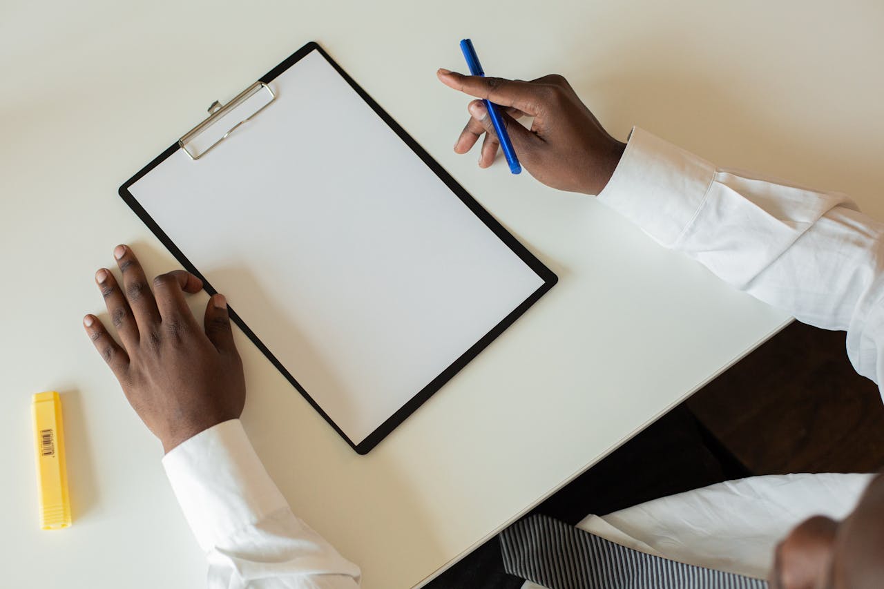 creative-03 Overhead shot of a businessman with a clipboard and pen on a desk, ready to take notes.